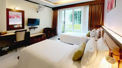 a hotel room with two beds and a television at The Mareeya Place in Kamala Beach