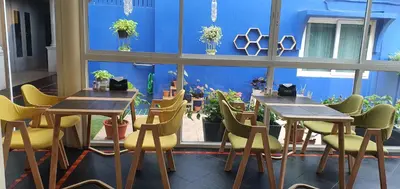 a room with tables and chairs and a large window at The Mareeya Place in Kamala Beach