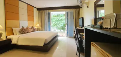a hotel room with a bed and a television at The Mareeya Place in Kamala Beach