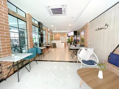 a restaurant with tables and chairs in a building at Le Cartier in Patong Beach