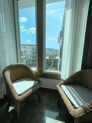 two chairs sitting in a room with two windows at Le Cartier in Patong Beach