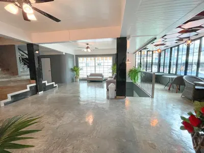 a lobby with a couch and tables and windows at Le Cartier in Patong Beach
