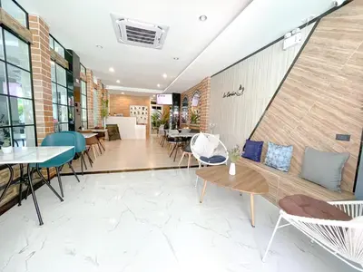a restaurant with tables and chairs in a building at Le Cartier in Patong Beach