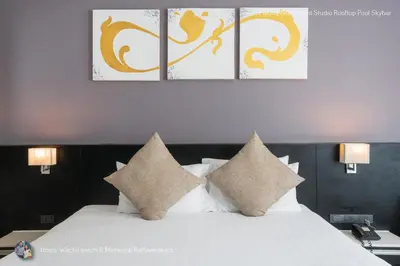 a bedroom with two beds and two paintings on the wall at ✪✪✪✪✪ Patong Beachfront Studio Rooftop Pool Skybar in Patong Beach