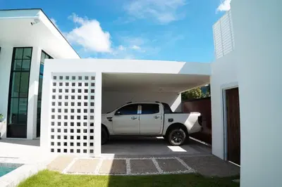 a white truck parked in a garage next to a house at BAANKAAN Pool Villa 1 in Ban Khlong Haeng