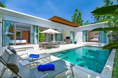 an outdoor swimming pool with chairs and a villa at Sunny 3BR Villa with Private Pool at Bangtao Beach in Bang Tao Beach