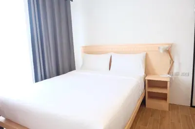 a bedroom with a white bed and a window at B3 HOUSE in Kamala Beach