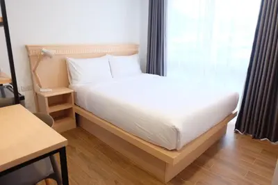 a white bed in a room with a window at B3 HOUSE in Kamala Beach