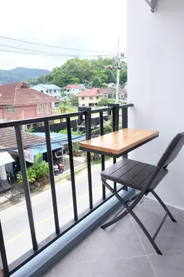 a table and a chair on a balcony with a view at B3 HOUSE in Kamala Beach