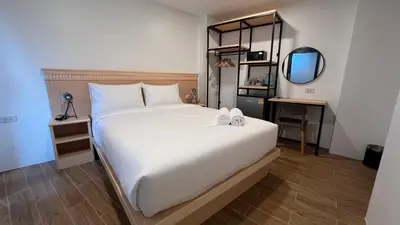 a bedroom with a large white bed and a mirror at B3 HOUSE in Kamala Beach