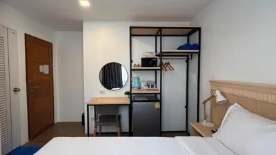 a bedroom with a bed and a desk with a mirror at B3 HOUSE in Kamala Beach