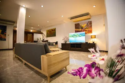a living room with a couch and a flat screen tv at Rico's Patong Hotel in Patong Beach