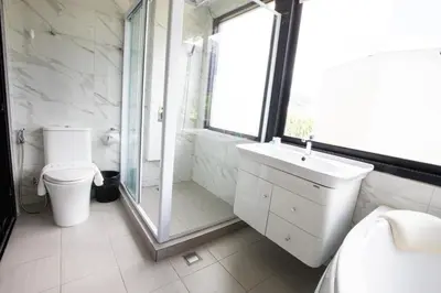 a bathroom with a shower and a toilet and a sink at Rico's Patong Hotel in Patong Beach