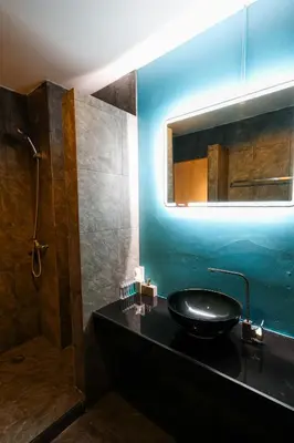 a bathroom with a black sink and a mirror at Rico's Patong Hotel in Patong Beach
