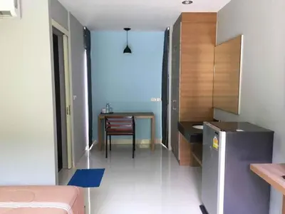 a room with a kitchen with a table and a dining room at Phumi Resort in Thalang