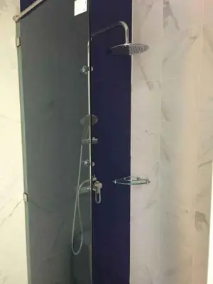 a shower with a glass door in a bathroom at Phumi Resort in Thalang