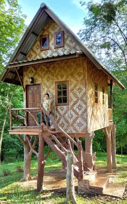 a woman standing in front of a tree house at Treehouse Holidays-Family house in Ko Yao Noi