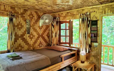 a bedroom with a bed in a log cabin at Treehouse Holidays-Family house in Ko Yao Noi