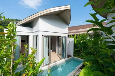 a house with a swimming pool next to a garden at Panwaburi Beachfront Resort - SHA Extra Plus in Panwa Beach