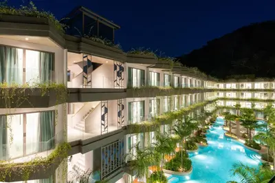 an apartment building with a swimming pool at night at Panwaburi Beachfront Resort - SHA Extra Plus in Panwa Beach