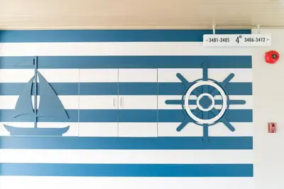 a wall with a blue and white wall with a boat and a compass at Panwaburi Beachfront Resort - SHA Extra Plus in Panwa Beach