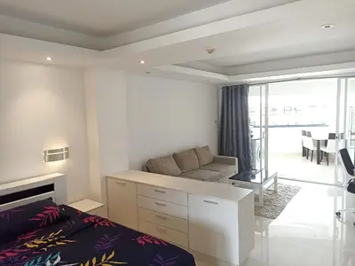 a bedroom with a bed and a couch and a living room at Patong beach apartment for up to 4 person in Patong Beach