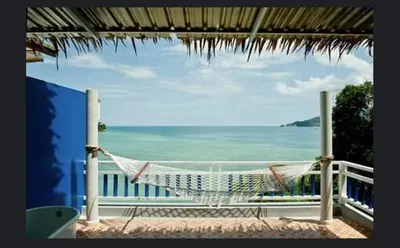 a hammock on a balcony with a view of the ocean at AT SEA Patong in Patong Beach
