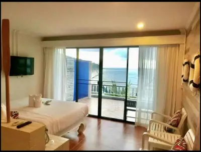 a bedroom with a bed and a view of the ocean at AT SEA Patong in Patong Beach