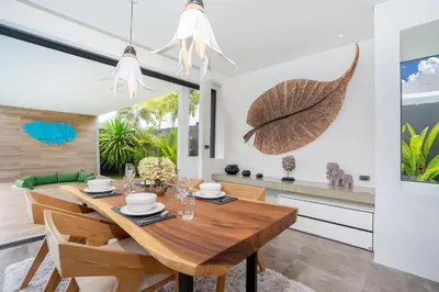 a dining room with a wooden table and chairs at Blue Coral Luxury Villa - Tropical Modern Living in Phuket Town