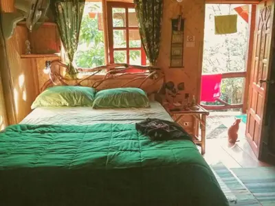 a bedroom with a bed with a green comforter at Treehouse Holidays-Garden View in Ko Yao Noi