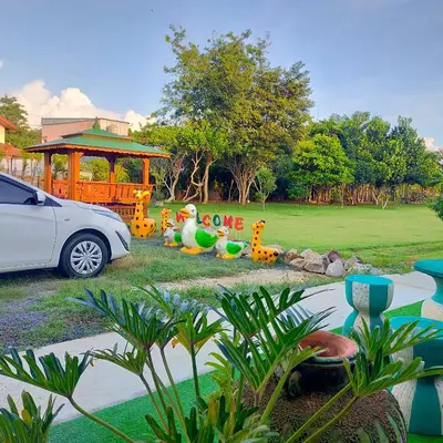 a car parked in front of a park with toy animals at Davy Cottage Phuket in Thalang