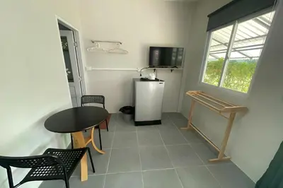 a room with a table and a small refrigerator at Davy Cottage Phuket in Thalang