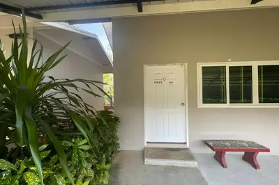 a porch with a white door and a bench at Davy Cottage Phuket in Thalang