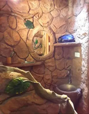 a stone bathroom with a toilet in a stone wall at Treehouse Holidays-Love Nest in Ko Yao Noi