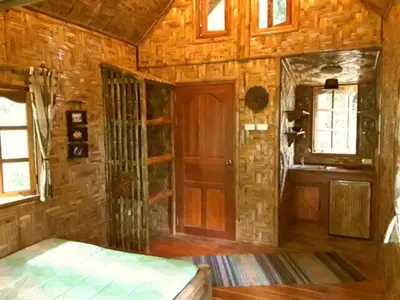 a room with a bed and a wooden wall at Treehouse Holidays-Love Nest in Ko Yao Noi