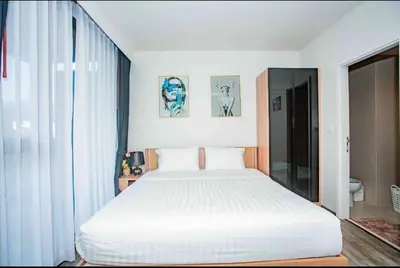 a bedroom with a large white bed in a room at The Deck Patong in Patong Beach