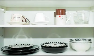 a shelf with plates and cups and bowls on it at The Deck Patong in Patong Beach