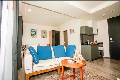 a living room with a white couch and blue pillows at The Deck Patong in Patong Beach