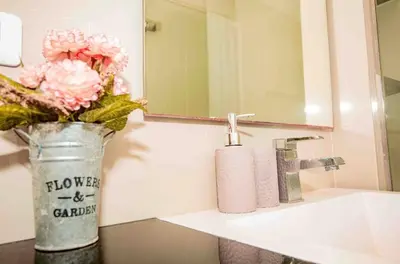 a bathroom with a vase with flowers on a sink at The Deck Patong in Patong Beach