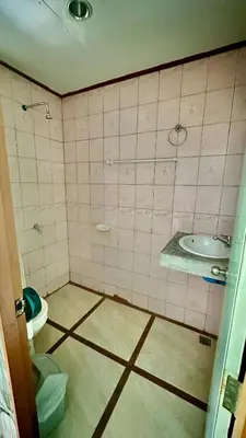 a tiled bathroom with a toilet and a sink at Andaman Resort in Phi Phi Don