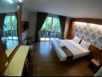 a bedroom with a large bed and a balcony at Andaman Resort in Phi Phi Don