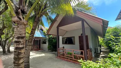 a small house with a palm tree next to it at Andaman Resort in Phi Phi Don