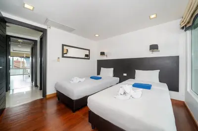 two beds in a hotel room with white sheets at Holiday apartment at Palms, 100 meters to beach in Kamala Beach