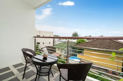 a balcony with a table and chairs and a view at Holiday apartment at Palms, 100 meters to beach in Kamala Beach