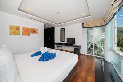 a bedroom with a white bed and a desk at Holiday apartment at Palms, 100 meters to beach in Kamala Beach