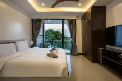a hotel room with a large bed with a television at Lovely pool villa 2 bedrooms in rawai with seaview in Ban Saiyuan (1)