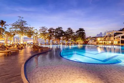 a large swimming pool with tables and chairs at night at Royal Yao Yai Island Beach Resort in Ko Yao Yai