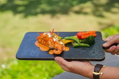 a person holding a tray with seafood and vegetables at Royal Yao Yai Island Beach Resort in Ko Yao Yai
