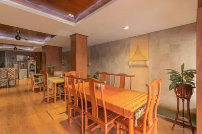 a dining room with a wooden table and chairs at Lotus Hotel Patong in Patong Beach