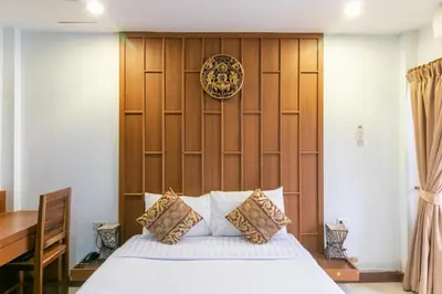 a bedroom with a bed and a wooden wall at Lotus Hotel Patong in Patong Beach
